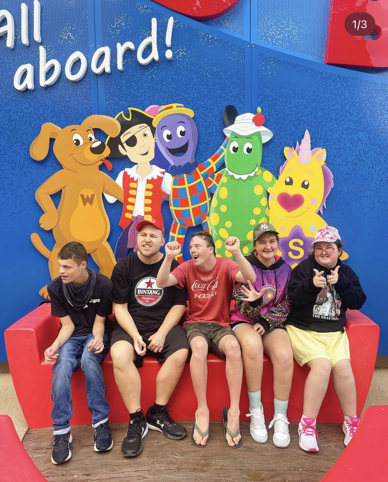 Rize participants and support workers in front of a Wiggles mural
