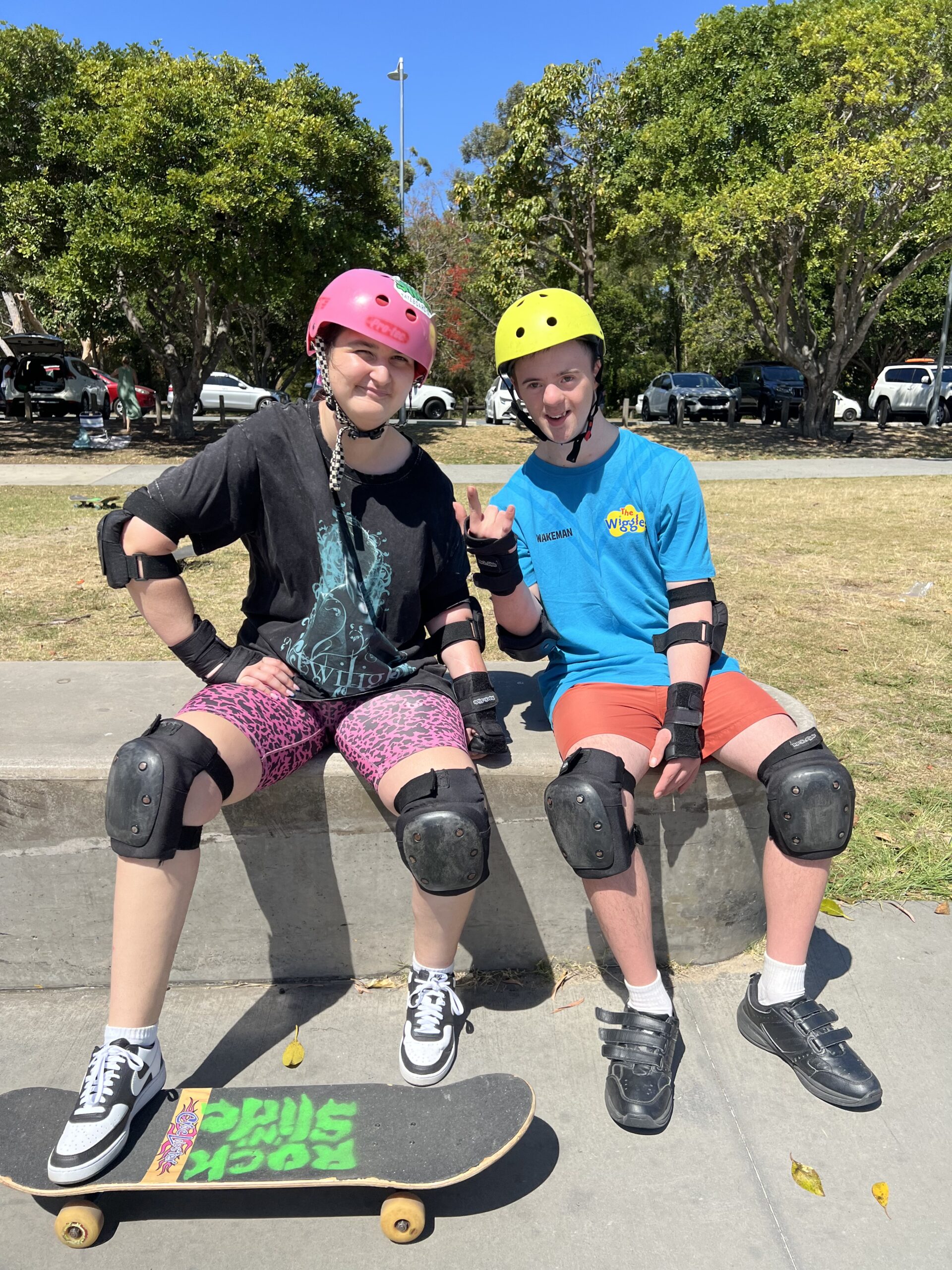 Two participants in skate safety gear at the park